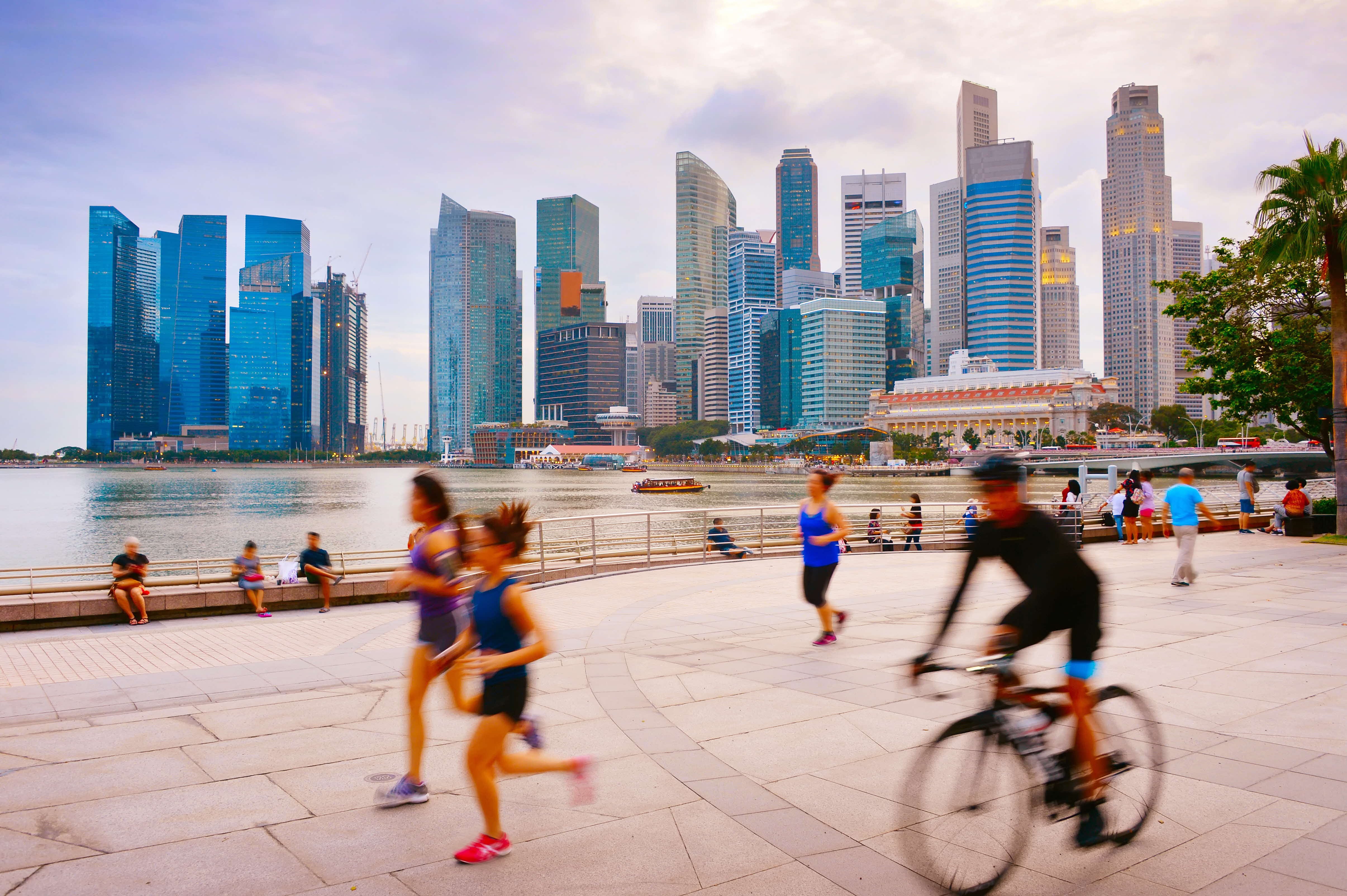 People jogging and cycling by Singapore River